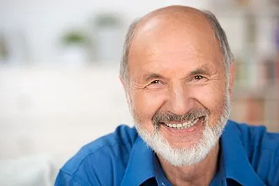 man showing off his newly restored smile thanks to dental implants from Moritis & Shin Dentistry